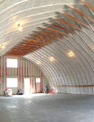 Spray Foam Insolation installed in a Large Industrial Space. Shop with well coted insolation.